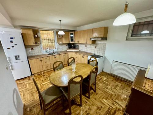 a kitchen with a table and chairs and a refrigerator at Stay and Chill house in Doglodi
