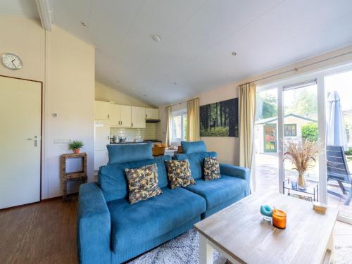 a living room with a blue couch and a table at Holiday Home in Voorthuizen near Veluwe Forest in Voorthuizen