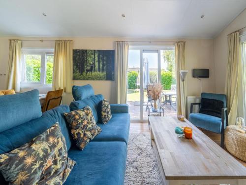 a living room with a blue couch and a wooden table at Holiday Home in Voorthuizen near Veluwe Forest in Voorthuizen