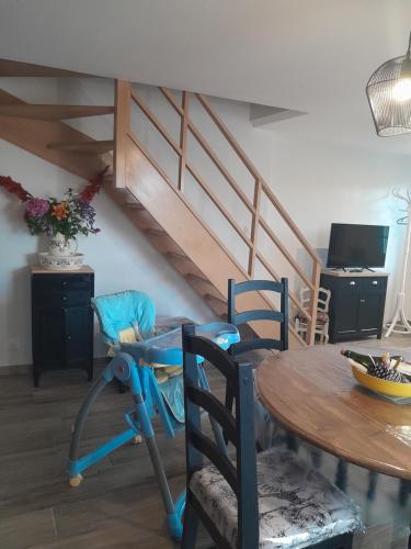 une pièce avec une table, des chaises et un escalier dans l'établissement Gîte tante Jeanne, à Réville