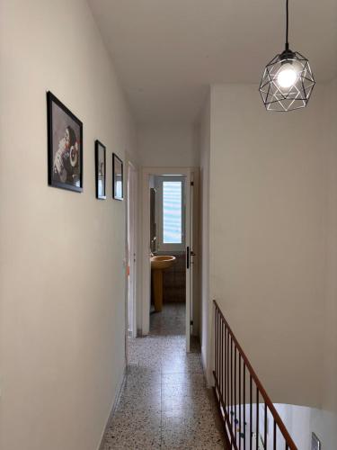 a hallway with white walls and a staircase with a light fixture at La Ginestra in Roccascalegna