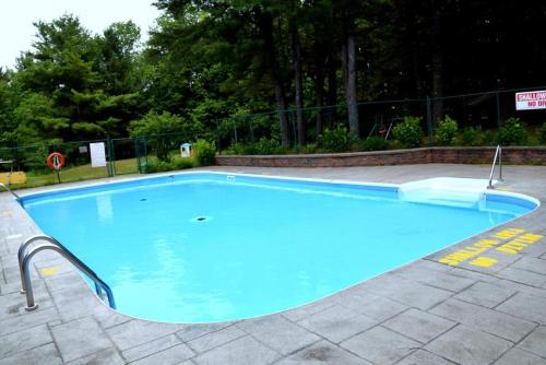 a large blue swimming pool in a yard at Cedar Lane Motel in Bracebridge