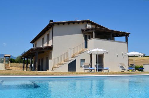 a house with two chairs and a swimming pool at La Cascina di Amela in Micarone
