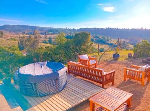 a deck with three benches and a bed on it at Soul House- Colinas y Mar in Navidad