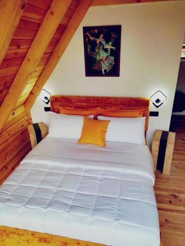 a bedroom with a white bed in a attic at Guest House Astrit Villi in Theth