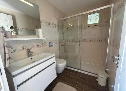 a bathroom with a sink and a shower and a toilet at Villa Panorama in Cesme