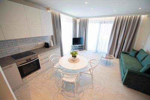 a kitchen and living room with a table and a couch at Avali Deluxe Apartments in Lygia
