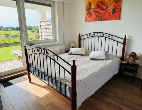 a bedroom with a bed and a large window at Na Poczatku - Apartamenty in Darłowo