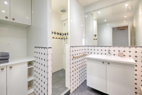 une salle de bain blanche avec un lavabo et un miroir dans l'établissement Saint Dominique - Perfect location - Eiffel Tower, à Paris