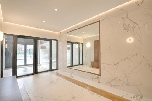 La salle de bains est pourvue de murs en marbre et d'un grand miroir. dans l'établissement Saint Dominique - Perfect location - Eiffel Tower, à Paris