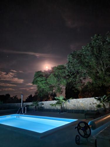 a swimming pool at night with the moon in the sky at Villa Sidro Krk in Žgaljić