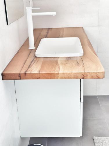 a white bathroom with a sink on a wooden counter at Villa Sidro Krk in Žgaljić