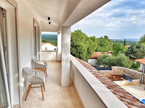 a balcony with two chairs and a view at Villa Sidro Krk in Žgaljić