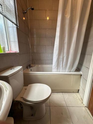 a bathroom with a toilet and a tub and a sink at Entire 2 Bedroom Cosy Flat Near City Centre in Manchester