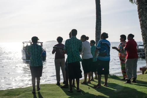 a group of people standing next to the water at Beqa Lagoon Resort in Beqa Island