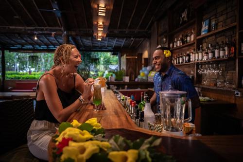a woman standing at a bar making a drink at Beqa Lagoon Resort in Beqa Island