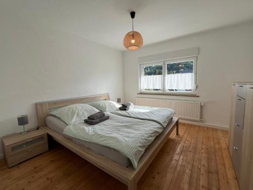 a bedroom with a bed and a window at Ferienhaus Naturtraum Eifel in Gerolstein