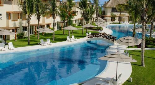 a large swimming pool with chairs and umbrellas at Hermosa Villa Acapulco Zona Diamante in Acapulco
