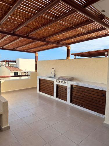 an outdoor kitchen with a sink and a stove at Hermosa Villa Acapulco Zona Diamante in Acapulco