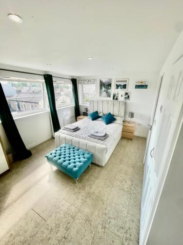 a bedroom with a bed and a blue stool at City Centre Cozy Studio flat Second Floor in Cambridge