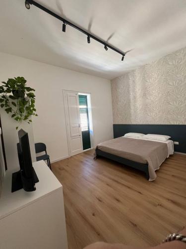 a bedroom with a bed and a flat screen tv at Spalti 33 in Trapani