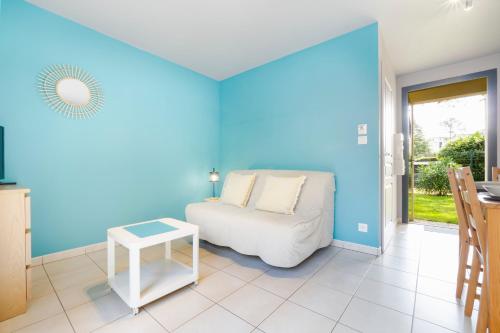 Cette chambre bleue comprend un lit et une table. dans l'établissement Studio 1 Cap Ouest Vacances, à Pornichet