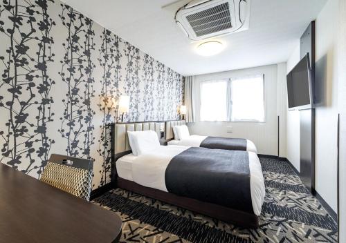 Postel nebo postele na pokoji v ubytování APA Hotel Miyazaki Nobeoka Ekimae