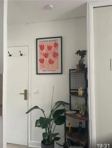 une chambre avec une plante et une photo sur le mur dans l'établissement Joli studio Batignolles Paris, à Paris