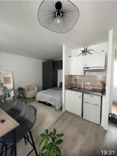 une chambre avec une cuisine et une chambre avec un lit dans l'établissement Joli studio Batignolles Paris, à Paris