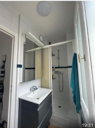 une salle de bain blanche avec un lavabo et une douche dans l'établissement Joli studio Batignolles Paris, à Paris