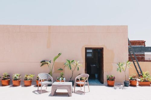 a patio with chairs and a table and potted plants at VIDA by Elegant Hospitality in Cairo