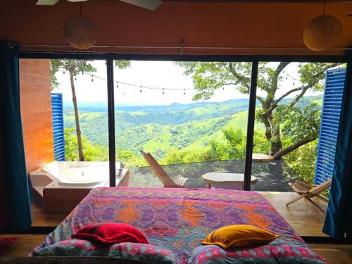 a bedroom with a view of a tub and a bed at El Sol Monteverde in Monteverde Costa Rica