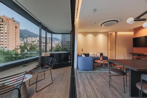 a living room with a couch and a table and chairs at Nock - Reserved Residences in Medellín