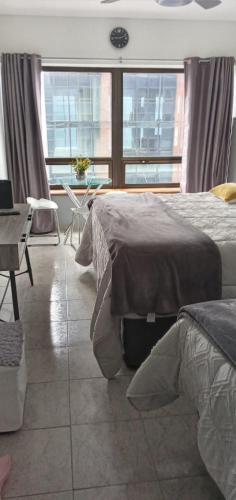 a bedroom with two beds and a table and windows at CORAZOn BUENOs AIREs PLATINo in Buenos Aires