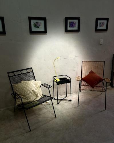 a room with two chairs and a table with a lamp at Casa Ufemia in Mérida