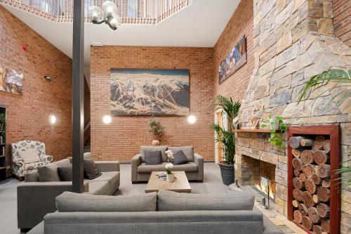 a living room with couches and a fireplace at Alpine Gables in Jindabyne