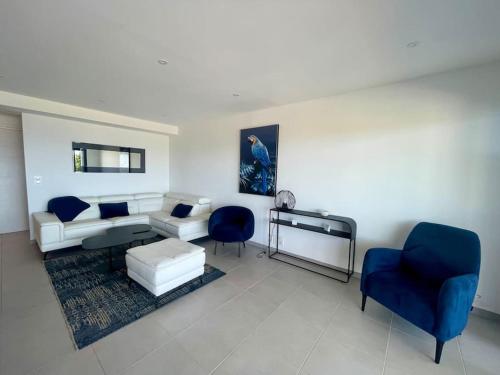 - un salon avec un canapé et deux fauteuils bleus dans l'établissement Villa Pietrosella, vue sur la baie d'Ajaccio, à Agnarelu