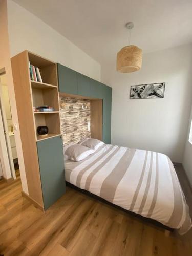 - une chambre avec un grand lit et une étagère dans l'établissement Appartement vue Port, à Perros-Guirec