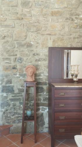 a dresser and mirror in a room with a stone wall at Antica Residenza Voso in Laureana Cilento