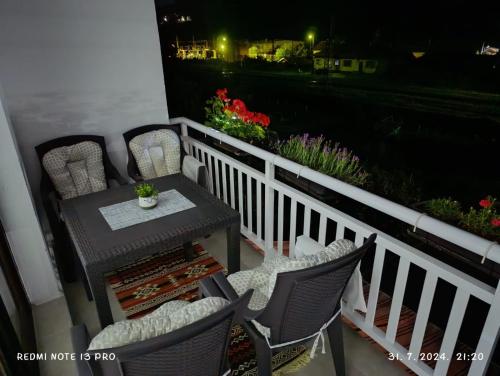 a table and chairs on a balcony at night at Apartment Happy Corner in Visoko