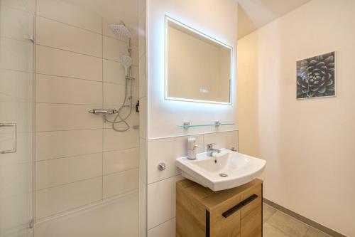 a white bathroom with a sink and a shower at Des Türmers Tochter Apartment in Delitzsch