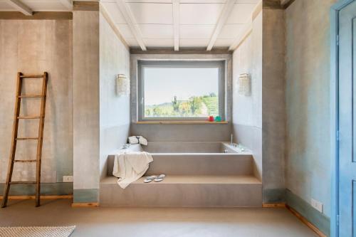 a bathroom with a bath tub and a window at ASILO in BAROLO in Barolo
