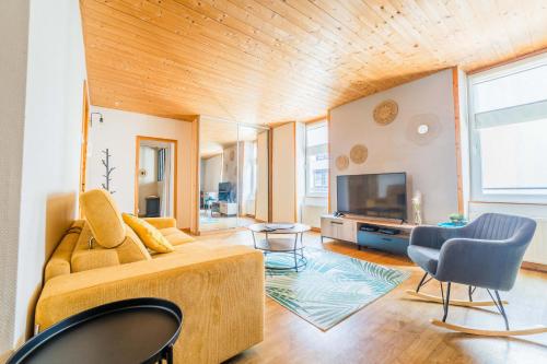 un salon avec un canapé et une télévision dans l'établissement Deux Chambres de Charme - 2 Chambres, à Brive-la-Gaillarde