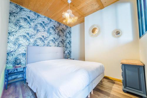 - une chambre avec un lit et un mur bleu et blanc dans l'établissement Deux Chambres de Charme - 2 Chambres, à Brive-la-Gaillarde