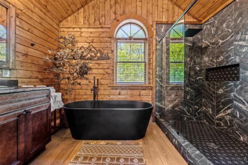 a large black tub in a bathroom with wooden walls at Grand View in Rocky Grove