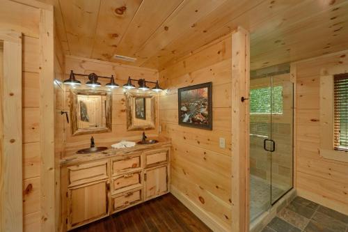 a log cabin bathroom with two sinks and a shower at Poolin Around in Waldens Creek