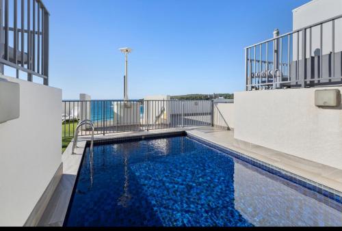 a swimming pool on the side of a building at The Little Beachside Apartment in Sydney