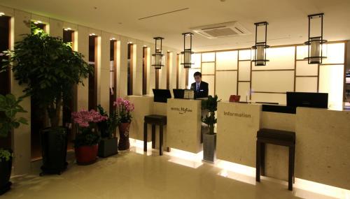 a man standing at a desk in a lobby at Hotel Migliore Seoul in Seoul