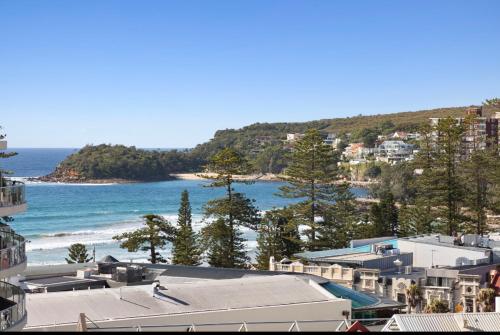 a view of a beach with buildings and the ocean at The Little Beachside Apartment in Sydney