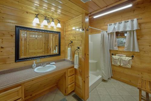 ガトリンバーグにあるCreeksong Holiday homeの洗面台、シャワー、鏡を備えたバスルーム